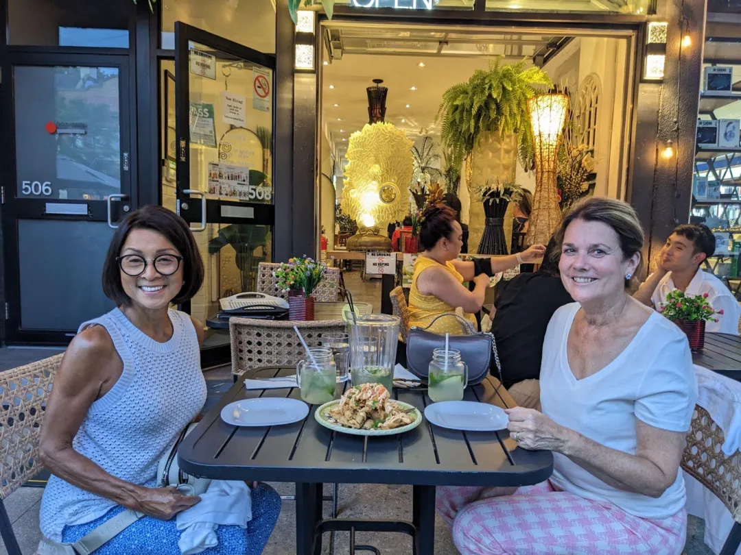 Diners on the Casa Manila Danforth patio at dusk under warm patio lights